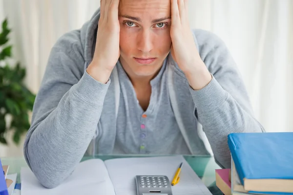 Portrait of a student holding his head — Stock Photo, Image