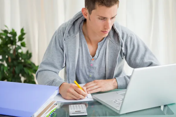 Студент делает домашнее задание с ноутбуком — стоковое фото