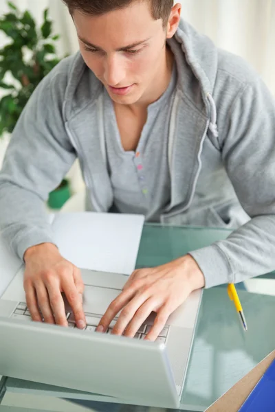 Primer plano de un estudiante escribiendo en un netbook —  Fotos de Stock
