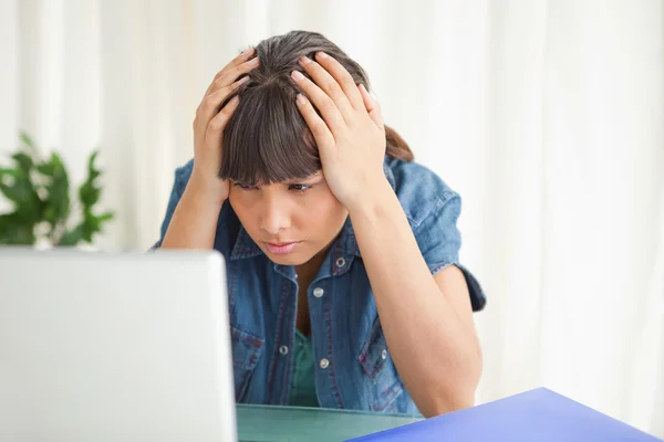 Deprimerad student tittar på hennes dator — Stockfoto