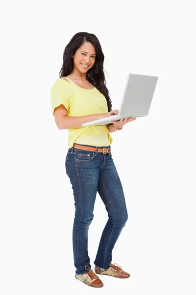 Portret uśmiechający się łaciński student stojący z laptopa — Zdjęcie stockowe