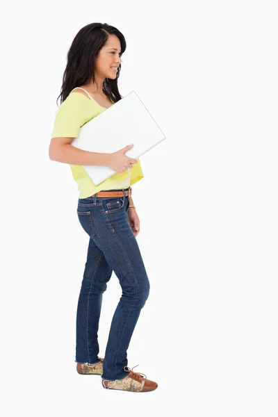 Vista lateral de un hermoso estudiante latino sosteniendo un portátil —  Fotos de Stock