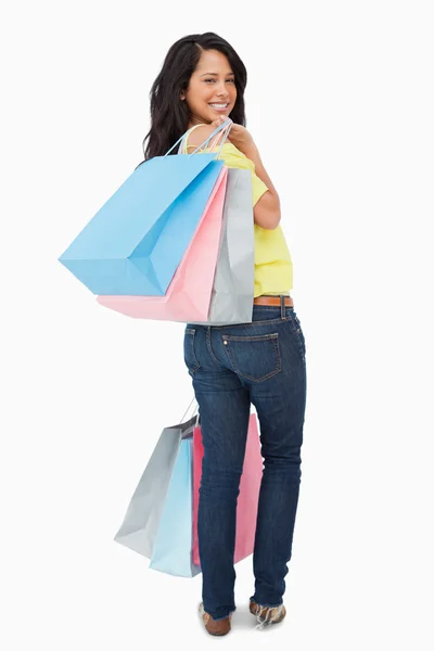 Rear view of a beautiful Latin student with shopping bags — Stock Photo, Image