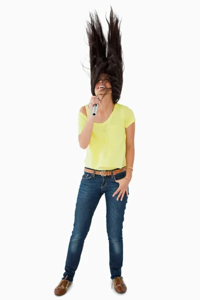 Jovem latina cantando enquanto balança a cabeça — Fotografia de Stock