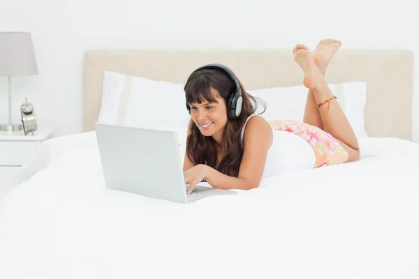 Genç kadın bir laptop earphones ile sohbet — Stok fotoğraf