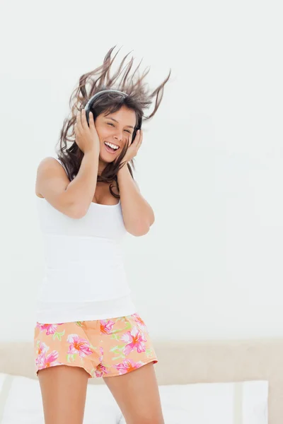 Studentin im Pyjama hört beim Springen Musik — Stockfoto