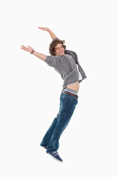 Gelukkig mannelijke student poseren door te springen — Stockfoto