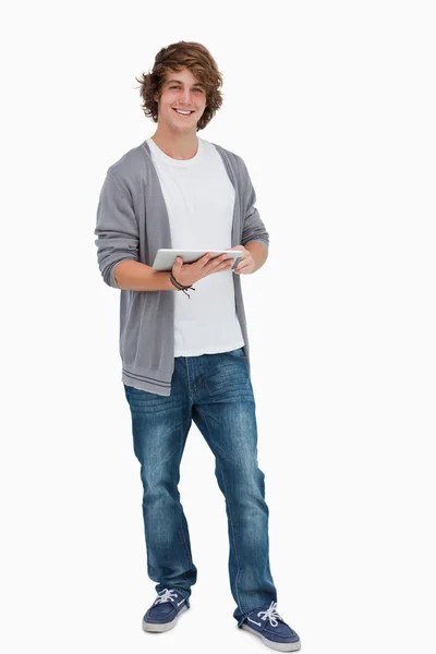 Estudiante masculino posando mientras sostiene una almohadilla táctil —  Fotos de Stock