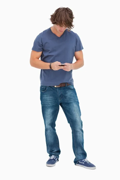 Manlig student med hjälp av sin mobiltelefon — Stockfoto