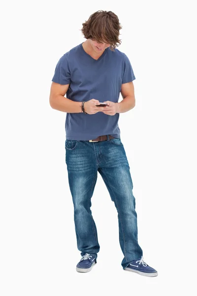 Ler manlig student med hjälp av sin mobiltelefon — Stockfoto
