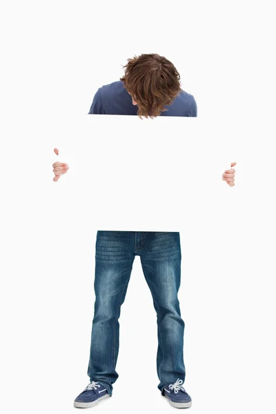 Estudiante masculino sosteniendo y mirando una pizarra blanca —  Fotos de Stock