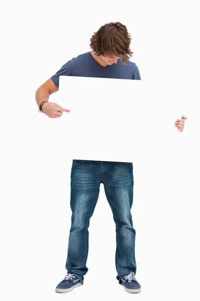 Männlicher Student hält und zeigt ein weißes Brett — Stockfoto