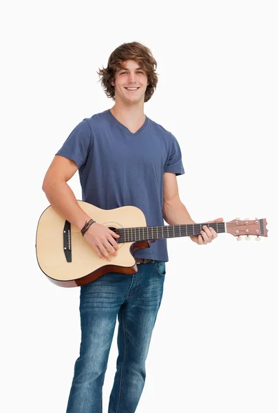 Estudante do sexo masculino posando enquanto segura uma guitarra — Fotografia de Stock