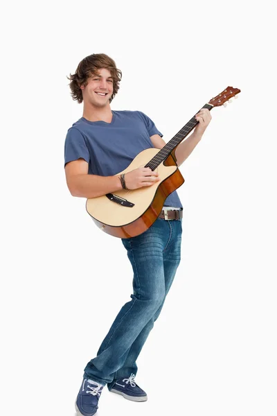 Mannelijke student die zich voordeed tijdens het spelen van gitaar — Stockfoto