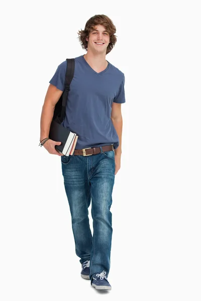 一名男同学和一个背包和书一起走的正面视图 — 图库照片
