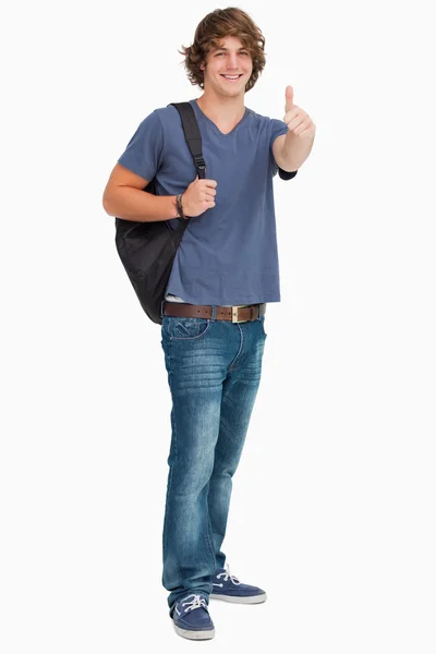 Ler manlig student med en ryggsäck på tummen-upp — Stockfoto