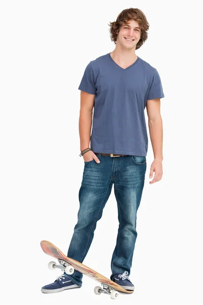 Lachende mannelijke student met een skateboard — Stockfoto