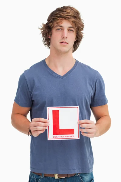 Młody człowiek trzyma znak kierowcy uczący się — Zdjęcie stockowe