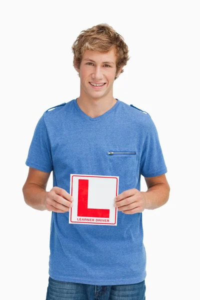 Joven rubio sosteniendo un letrero de conductor aprendiz — Foto de Stock