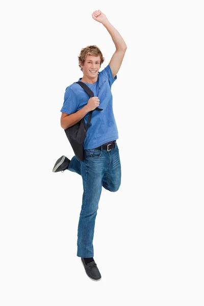 Junger blonder Mann springt mit Rucksack — Stockfoto