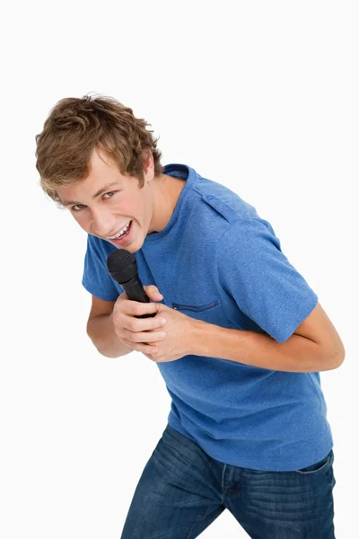 Портрет молодого человека, поющего с микрофоном — стоковое фото