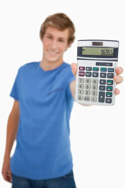 Ung man visar en miniräknare — Stockfoto
