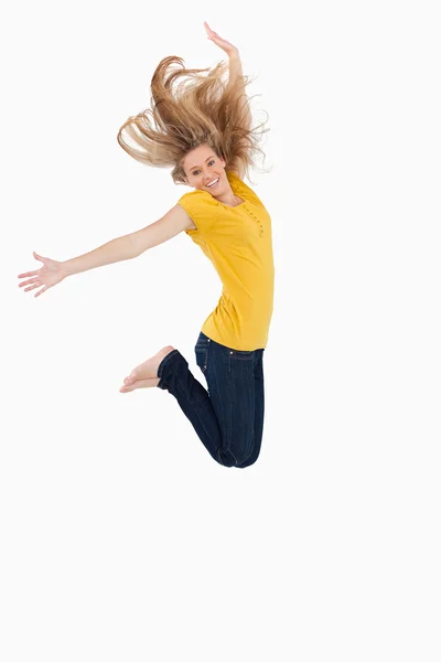 Femme blonde en chemise jaune sautant — Photo