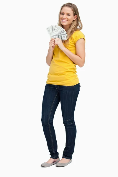 Mulher loira sorrindo enquanto segura um monte de dólares — Fotografia de Stock