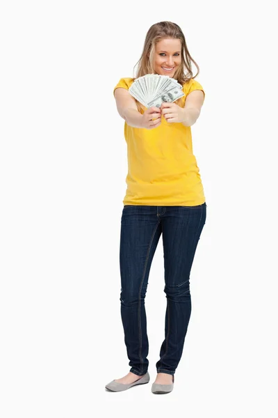 Mulher loira sorrindo enquanto mostra um monte de dólares — Fotografia de Stock