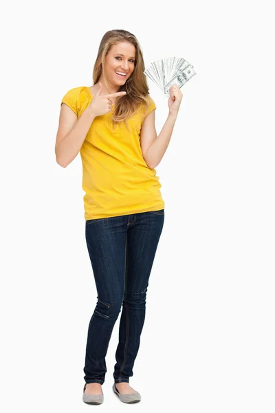 Schöne blonde Frau lächelt, während sie eine Menge Dollars zeigt — Stockfoto