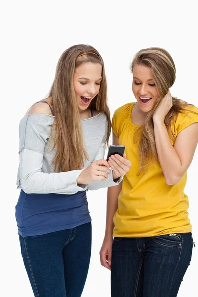 Dois estudantes surpresos olhando uma tela de celular — Fotografia de Stock