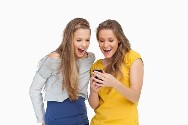 寻找一款智能手机的两个清音年轻妇女 — 图库照片