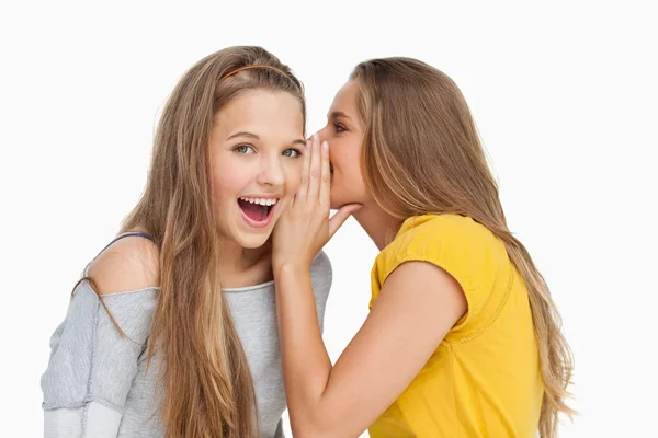 Blonde student fluisteren naar haar vriend — Stockfoto
