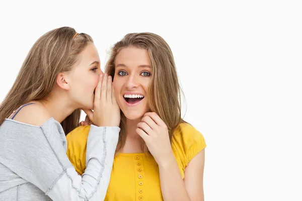 Blonde student whispering to a friend — Stock Photo, Image