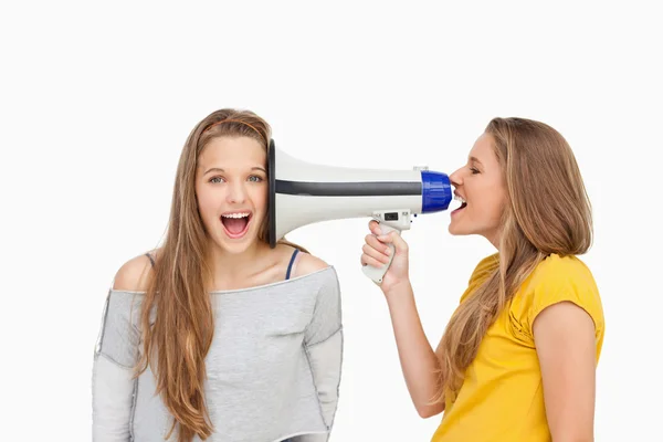 Blonde student met behulp van een luidspreker op haar vriend — Stockfoto