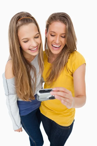 Dva přátelé smát při kontrole jejich obrázek na digitální c — Stock fotografie