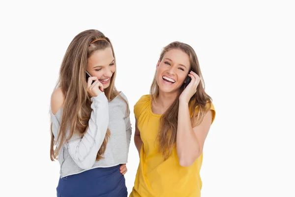Twee jonge vrouwen lachen aan de telefoon — Stockfoto