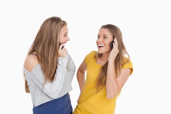 Duas jovens mulheres rindo ao telefone juntas — Fotografia de Stock