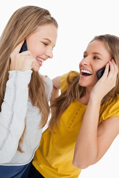 Närbild av två vackra studenter skrattar på telefonen — Stockfoto