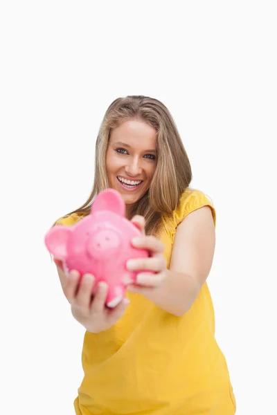 Jovem sorrindo mulher cuidando de um porquinho-banco — Fotografia de Stock