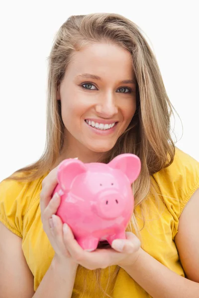 Portrait of a young blond woman holding a piggy-bank — Stock Photo, Image