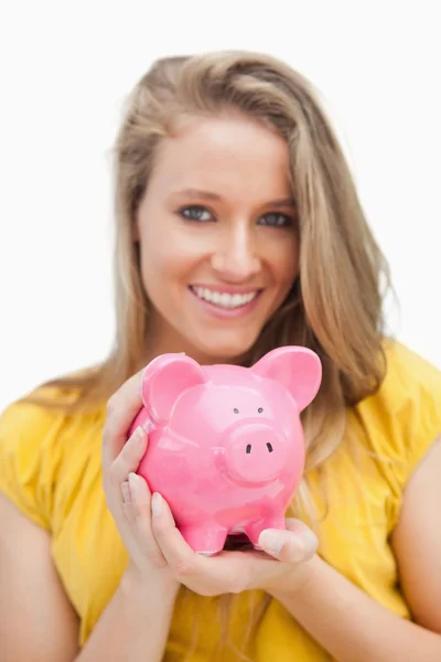 Close-up of a piggy-bank holding by a blond woman — Stock Photo, Image