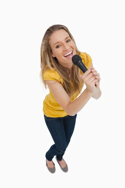 Fisheye view of blonde singing with a microphone — Stock Photo, Image