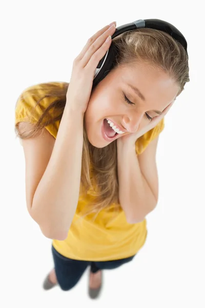 音乐用耳机欣赏一个金发女孩的鱼眼视图 — 图库照片