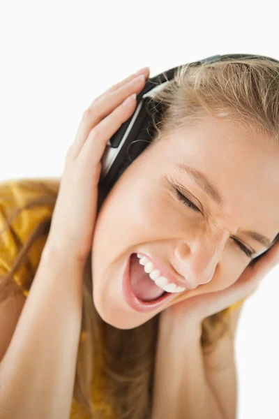 Egy szőke nő élvezi a zenét a fejhallgatót részlete — Stock Fotó