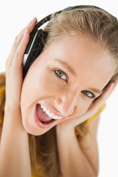 Nahaufnahme einer blonden Studentin, die Musik mit Kopfhörern genießt — Stockfoto