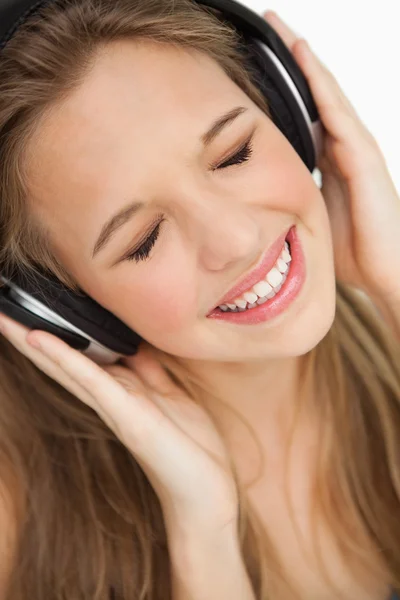Close-up de uma linda jovem loira ouvindo música — Fotografia de Stock
