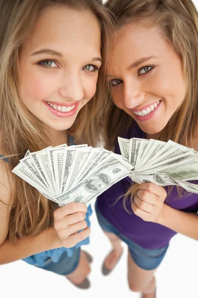 Hochwinkelaufnahme zweier glücklicher junger Schönheiten, die Dollars in der Hand halten — Stockfoto