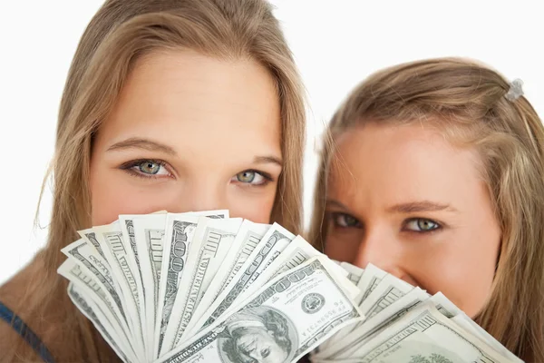 Close-up of two young woman behind dollars — Stock Photo, Image