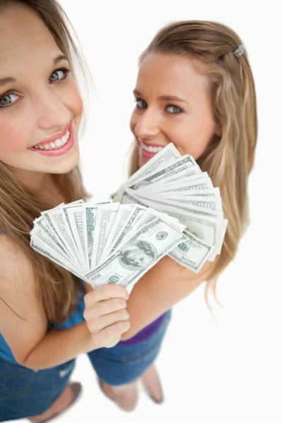 Pod dużym kątem widzenia młoda kobieta dwa gospodarstwa dolarów — Zdjęcie stockowe